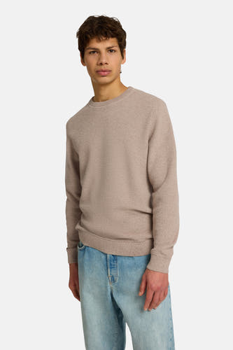 Pull marron avec col rond de SELECTED, à une texture subtile, porté avec un jean bleu.