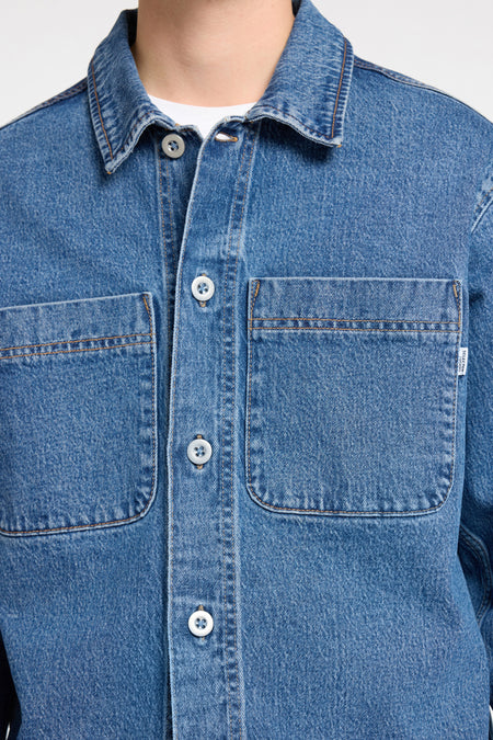 Denim overhemd in medium blauw van SELECTED Homme, met witte knopen en borstzakken.