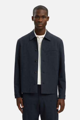Blauw overhemd met lange mouwen van SELECTED, gedragen over een wit poloshirt en gecombineerd met een bijpassende broek.