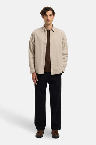 Beige hemd met lange mouwen van SELECTED, gedragen over een bruin shirt, met donkere broek en bruine schoenen.
