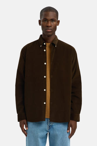 Bruin overhemd met lange mouwen van SELECTED, gedragen over een okerkleurig T-shirt en lichtblauwe jeans.
