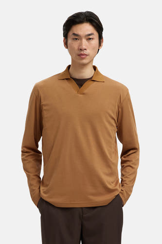 Polo beige de SELECTED, avec des manches longues et un col ouvert, porté avec un pantalon marron.