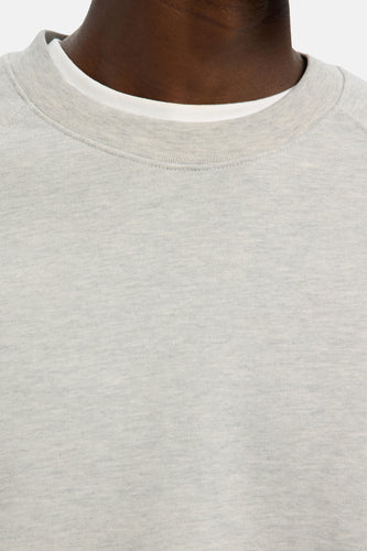 Grijze sweater met ronde hals, gedragen door een donker getinte man.