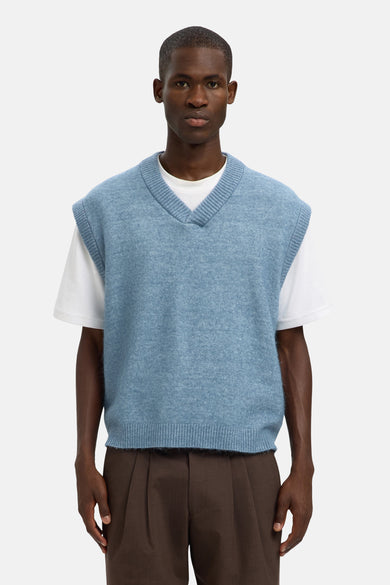 T-shirt bleu de SELECTED porté sur un T-shirt blanc, avec un pantalon marron.