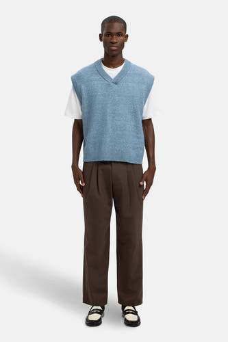 Blauw debardeur van SELECTED, gedragen over een wit T-shirt en gecombineerd met bruine pantalon en zwart-witte schoenen.
