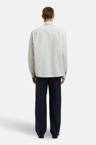 Wit, gestreept overhemd met lange mouwen van SELECTED, getoond in achteraanzicht met een donkerblauwe pantalon.
