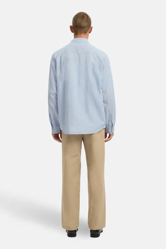 Chemise bleue à manches longues de SELECTED, vue de dos, associée à un pantalon beige et des chaussures noires.