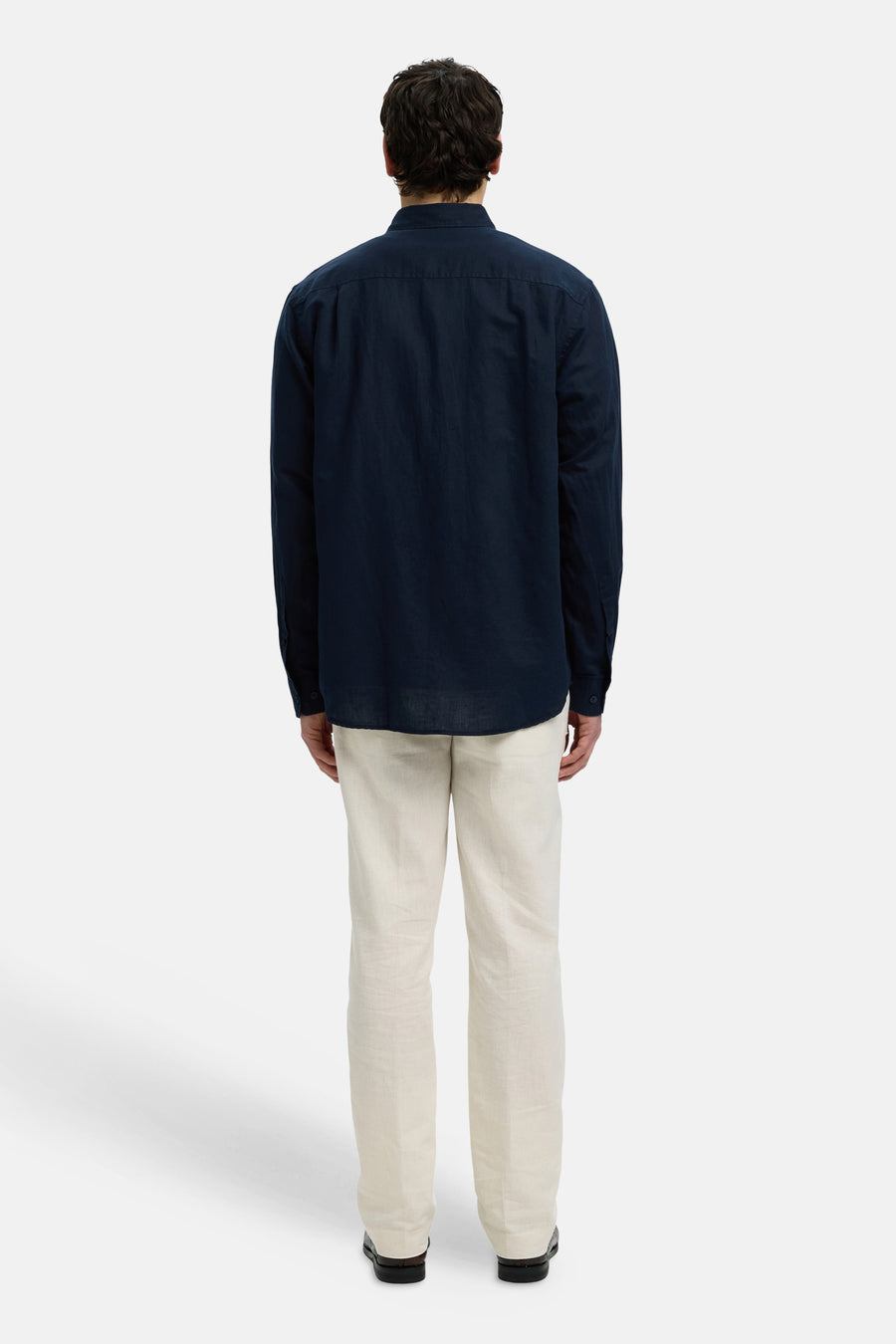 Blauw hemd met lange mouwen van SELECTED, van achteren gezien met lichte broek.