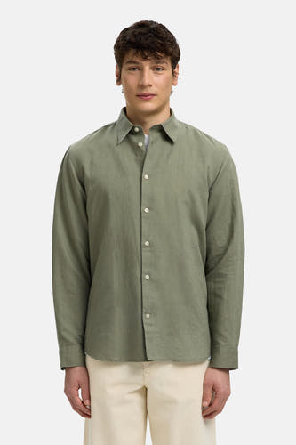 Groen hemd met lange mouwen van SELECTED met witte knopen en open kraag, gedragen op een lichte broek.