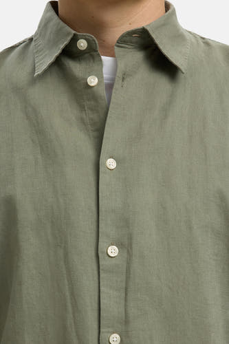 Groen overhemd met lange mouwen van SELECTED, met licht gestructureerde stof en open knoopsluiting boven een wit T-shirt.
