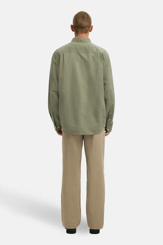 Groen overhemd met lange mouwen van SELECTED, met knoopsluiting en gedragen met kaki broek, gezien van achteren.
