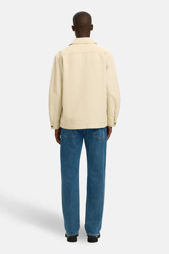 Ecru hemd van SELECTED, gezien van achteren, gecombineerd met jeans en zwarte schoenen.