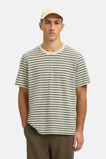 T-shirt multicolore de SELECTED, à motif rayé, porté avec un short kaki et des sandales.