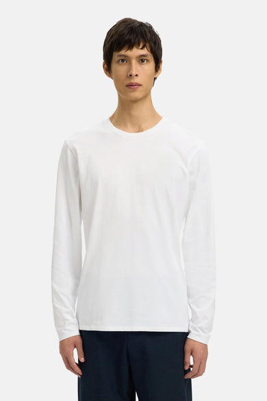 Wit shirt met lange mouwen van SELECTED, gedragen met een donkere broek, voor een neutrale achtergrond.
