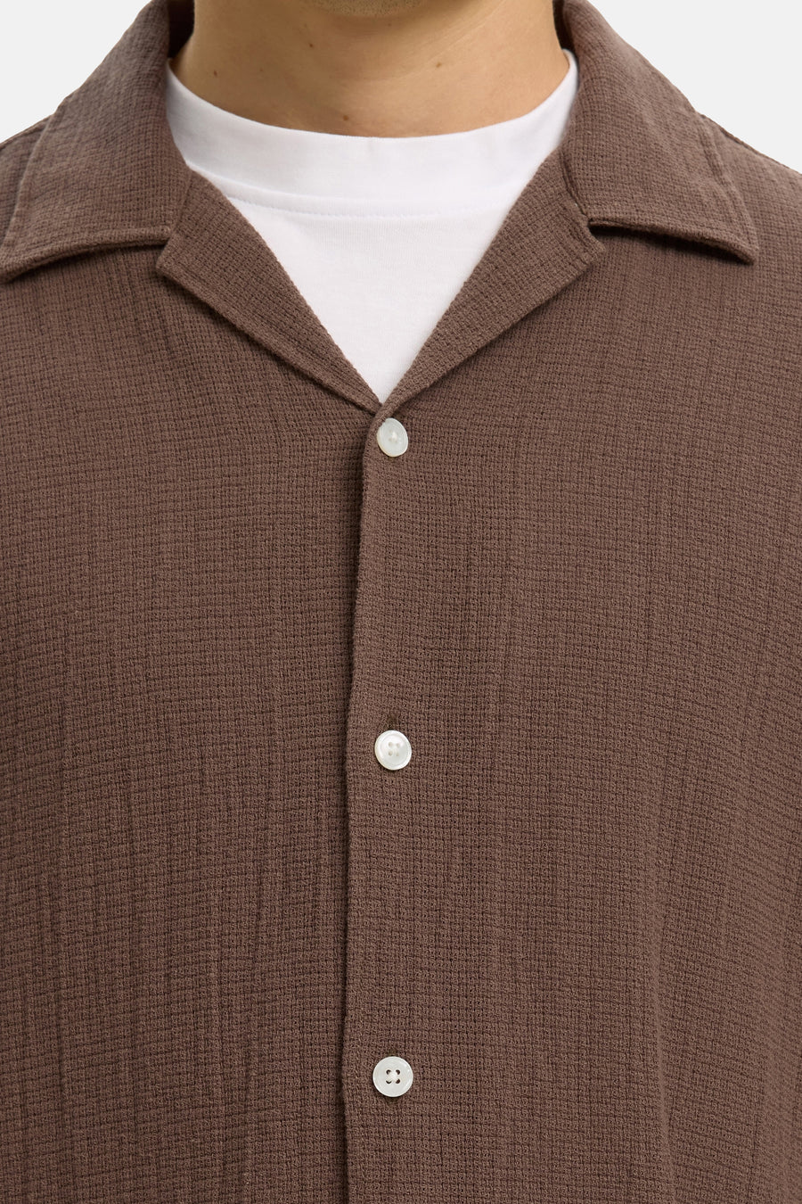 Bruin overhemd met korte mouwen van SELECTED, met resortkraag, gestructureerde stof en witte knopen over een wit T-shirt.