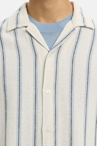 Ecru overhemd van SELECTED met korte mouwen, gestreept patroon en gedragen over een lichtblauw T-shirt.