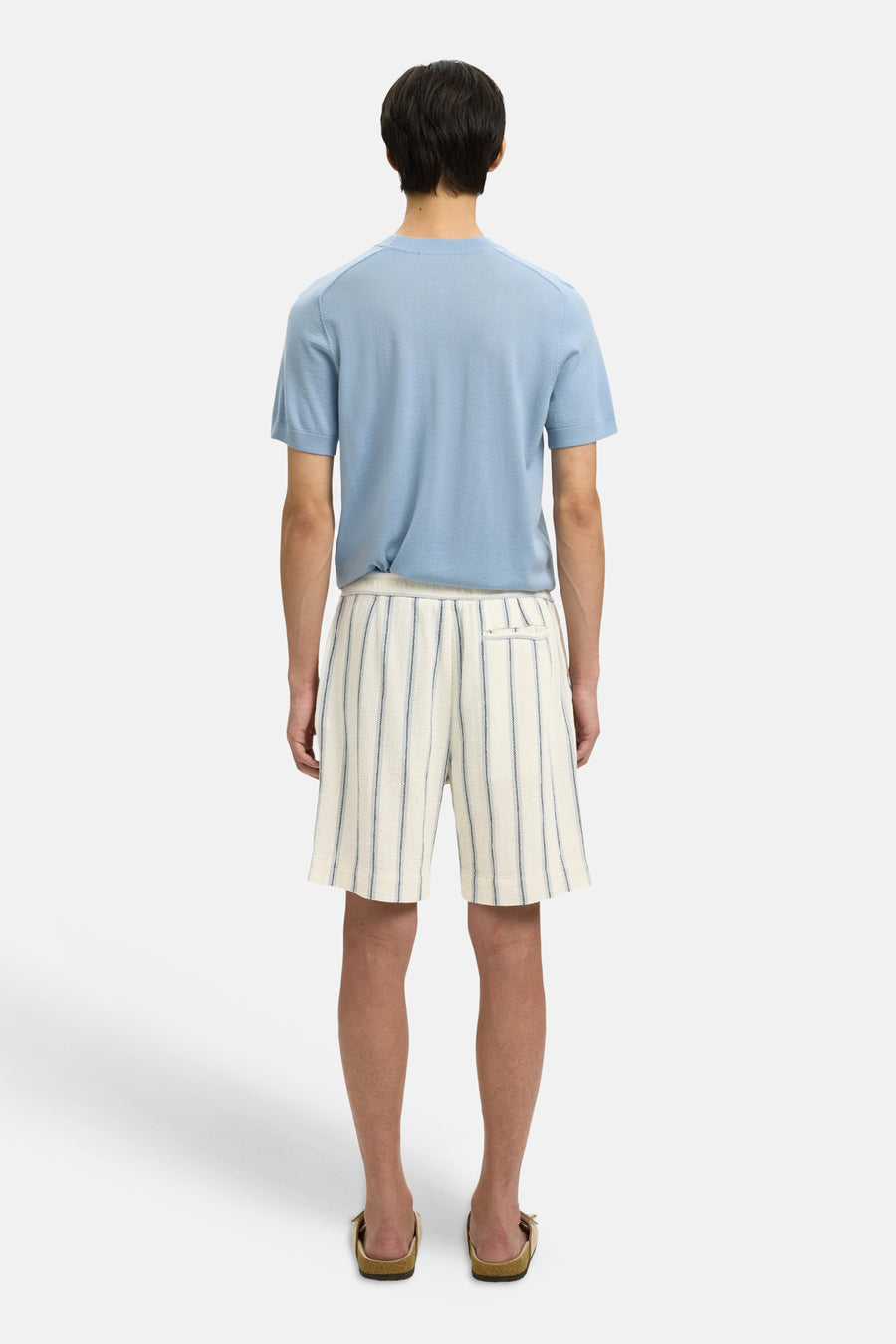 Ecru gestreepte korte broek van SELECTED, achterkant, met fijne donkere strepen en zak, gedragen met lichtblauw shirt en sandalen