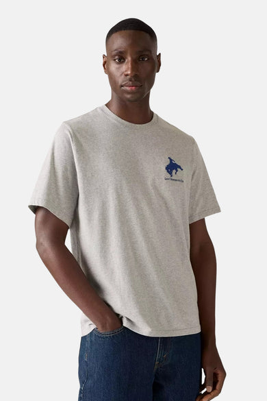 T-shirt gris à manches courtes de Levi's®, avec un petit logo sur la poitrine, porté avec un jeans bleu foncé.