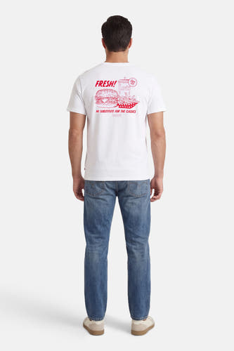 T-shirt blanc à manches courtes de Levi's, avec imprimé rouge au dos, porté avec un jean et des baskets.