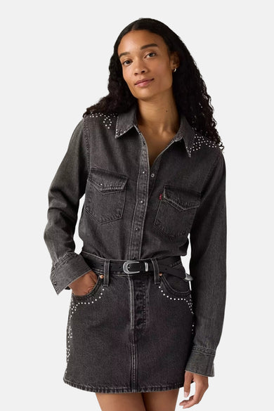 Zwart denim overhemd met lange mouwen van Levi's®, versierd met studs op de schouders en zakken, gecombineerd met een zwarte rok.
