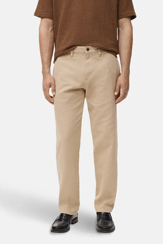 Beige colorbroek van MANGO, met een bruin shirt en zwarte schoenen.
