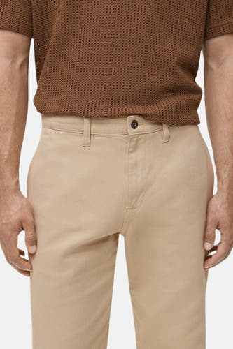 Beige colorbroek van MANGO, met een enkele knoopsluiting en riemlussen.
