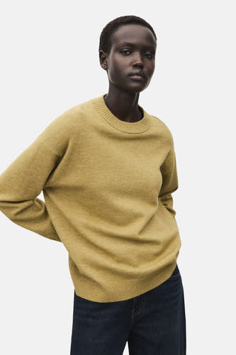 T-shirt vert avec col rond de MANGO, porté avec des jeans noirs.