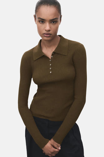 Khaki trui met ronde hals van MANGO, geribd en met lange mouwen, gecombineerd met een zwarte broek.
