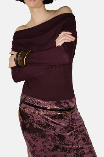 Bordeaux trui met ronde hals van MANGO, met lange mouwen, gedragen met een paarse rok met bloempatroon.
