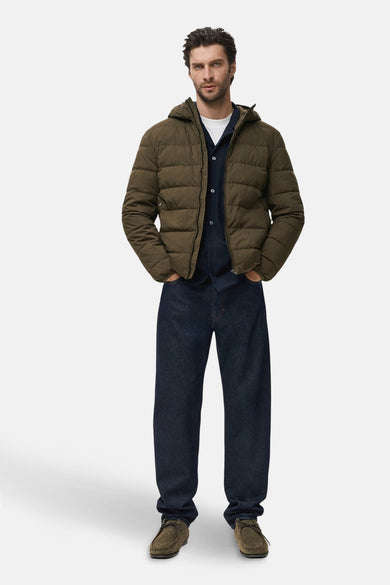 Korte kaki jas van MANGO, gedragen met een blauw overhemd, een wit T-shirt en donkerblauwe jeans.