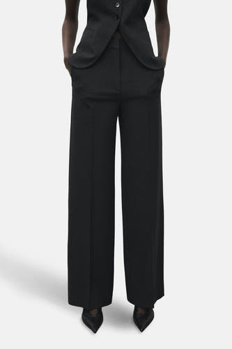 Pantalon gris de costume MANGO, avec des jambes larges et des poches à rabat, associé à un gilet coordonné.