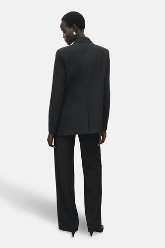 Pantalon gris de costume MANGO, vu de l'arrière, avec des jambes larges et un collet correspondant.