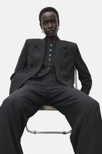 Pantalon de costume gris MANGO, largeur ample, associé à un gilet coordonné et un blazer double boutons.