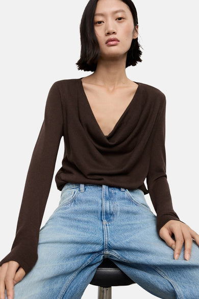 Bruine trui met ronde hals van MANGO, gecombineerd met een lichte jeans in een casual setting.
