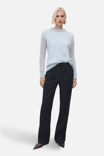 Blauwe trui met ronde hals van MANGO, gecombineerd met een donkere pantalon met wijde pijpen en puntige schoenen.