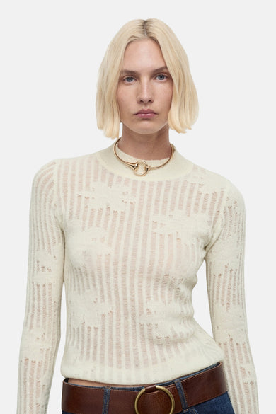 Beige trui met ronde hals van MANGO, met verticale strepen en een bruine riem.
