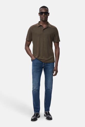 Blauwe slim-fit jeans van MANGO, gecombineerd met een bruin poloshirt en zwarte leren loafers.