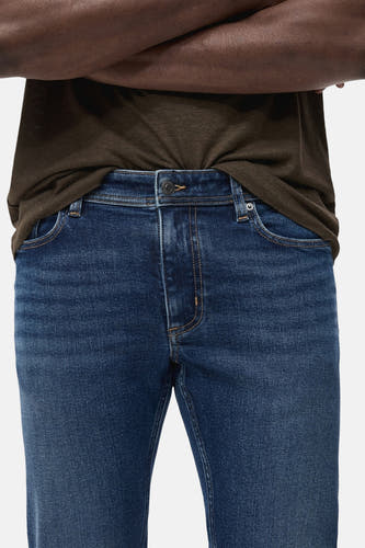 Slim fit jeans van blauw denim van MANGO, met een zichtbare knoopsluiting.