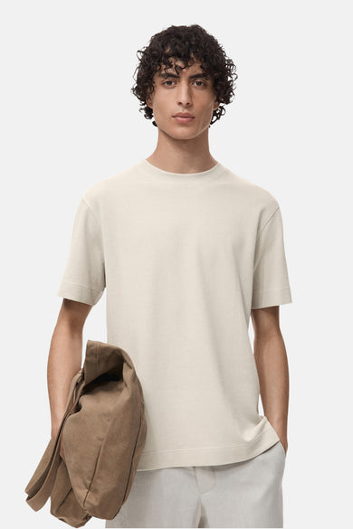 Gris, T-shirt à manches courtes de MANGO avec une texture rayée et un sac marron sur l'épaule.