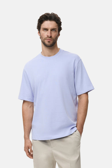 Blauw T-shirt met korte mouwen van MANGO, gedragen met een beige pantalon.

