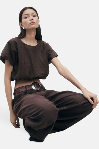 Bruine blouse met korte mouwen van MANGO, gedragen met een bruine broek en riem met zilveren gesp.