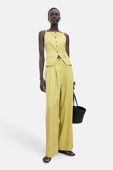 Blouse verte verte sans manches MANGO, avec fermeture à boutons et fines rayures, associée à un pantalon à larges jambes.