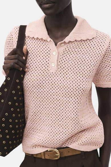 Roze polo met korte mouwen van MANGO, met een gehaakte textuur en gedragen met een bruine tas.
