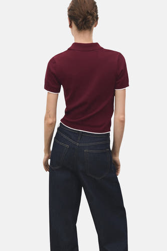 Bordeaux trui met ronde hals van MANGO, met korte mouwen en gecombineerd met donkere jeans, achteraanzicht.
