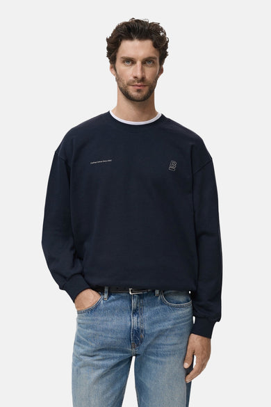 Blauwe sweater met ronde hals van MANGO, met minimalistische details en gedragen met jeans.
