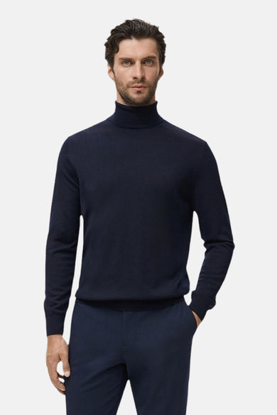 T-shirt à col rond bleu de MANGO, avec des manches longues et un design simple, associé à un pantalon bleu marine.