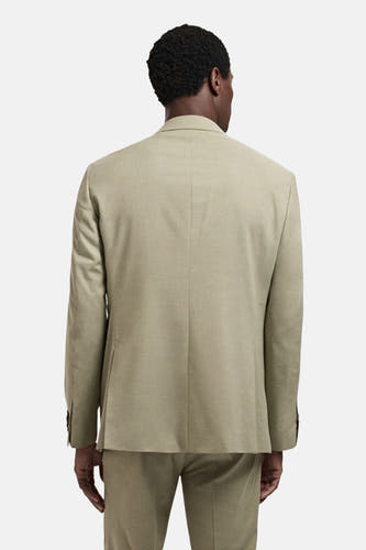 Blazer vert de MANGO, avec une texture lisse sur le dos et des boutons discrets sur les poignets.
