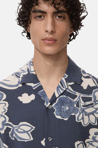 Chemise bleue à manches courtes de MANGO, avec imprimé fleuri et col boutonné.