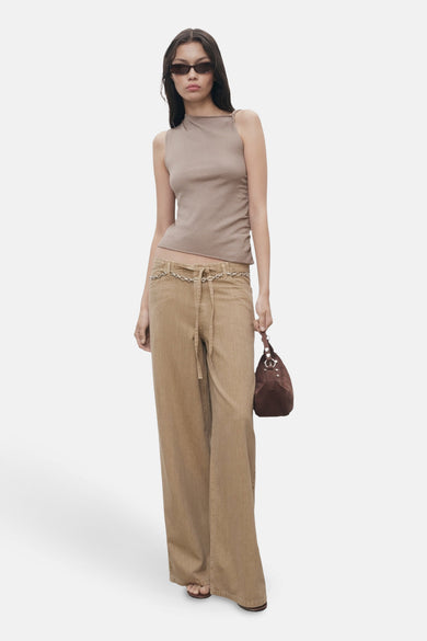 Beige gekleurde jeans van MANGO met een kettingriem, gecombineerd met een bruine top en tas.