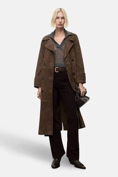 Bruine broek van MANGO, gecombineerd met een bruine suède trenchcoat, grijze trui en bruine riem met gouden gesp.